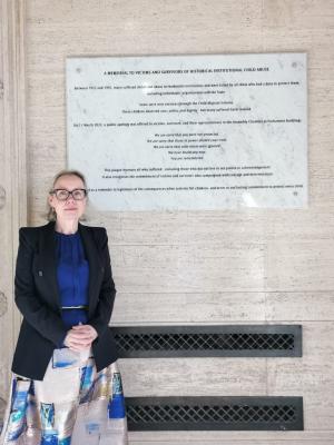 Photo of Commissioner for Survivors of Institutional Childhood Abuse, Fiona Ryan, at the memorial plaque to victims and survivors at Parliament Buildings, Stormont